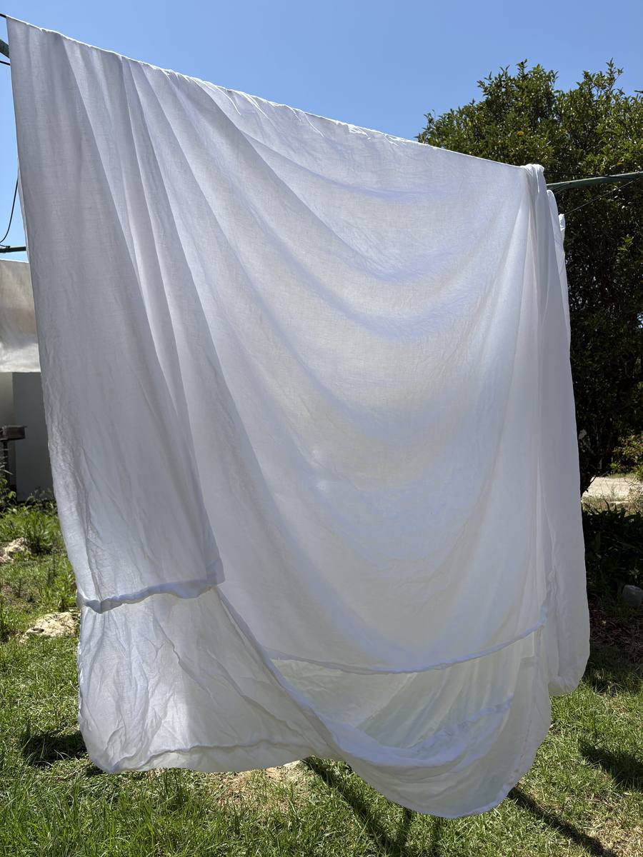 White linens drying on the line in the orchard sun