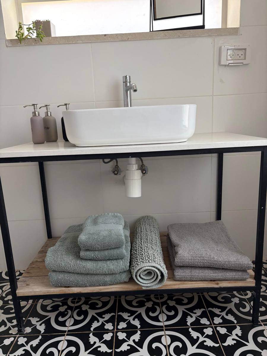 Towel sets and bathrobes folded under the bathroom sink
