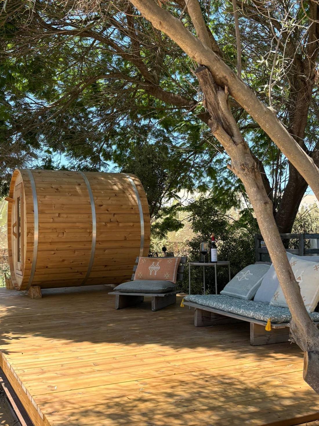Barrel sauna and cushioned loungers on the wooden spa deck